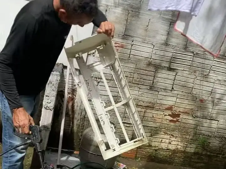 Técnico da Polo Norte lavando as peças do ar-condicionado