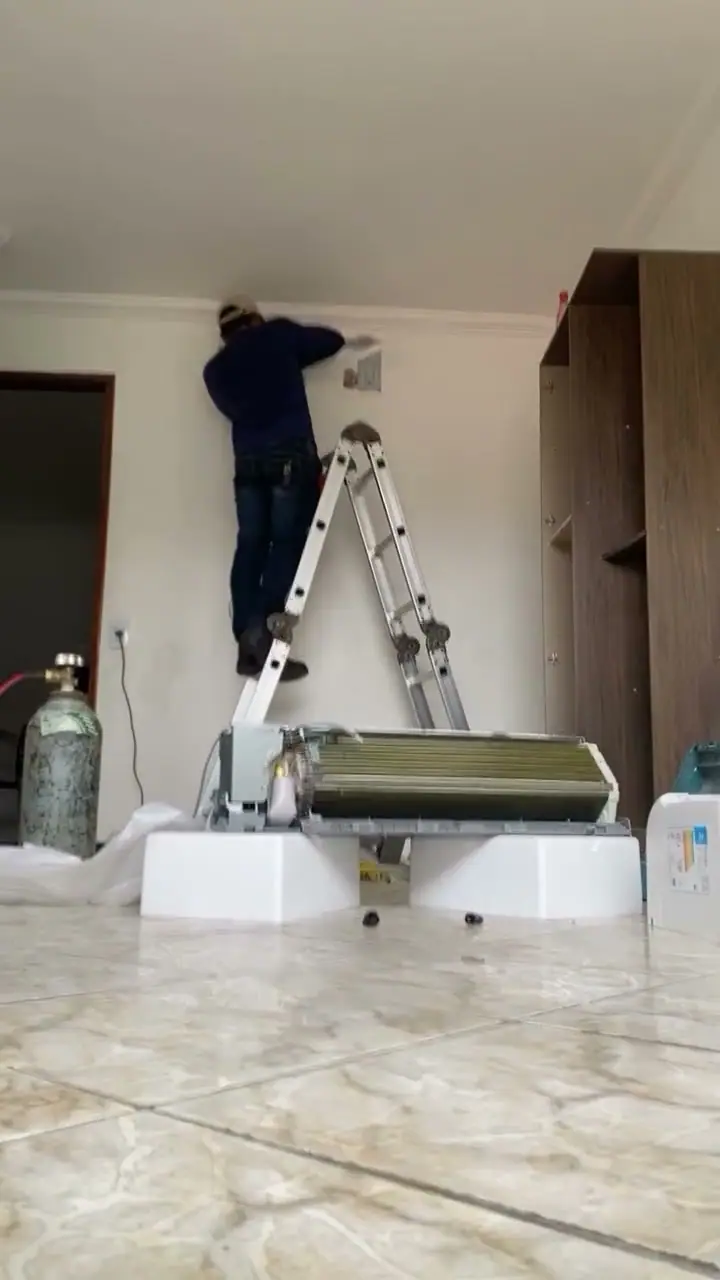Técnico da Polo Norte na escada instalando a evaporadora de um ar-condicionado